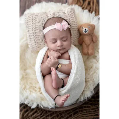 A perfect, peaceful portrait of a sleeping newborn. In my cozy Borivali studio, I create a safe and warm environment where your baby can rest comfortably, allowing me to capture these classic, angelic poses. This little one is swaddled and sleeping next to her tiny teddy bear companion.