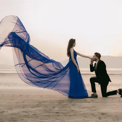 A true fairytale proposal on the beach. My royal blue trail gown creates a stunning visual as it catches the sea breeze, making for a truly memorable and romantic pre-wedding photo.