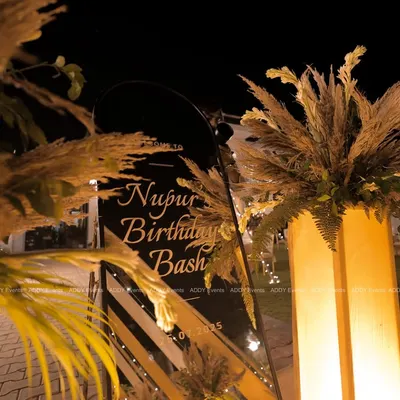 First impressions matter. For this birthday bash, we created a chic welcome sign on black acrylic, framed with pampas grass and lit by warm uplighting to set a sophisticated and celebratory mood from the very beginning.