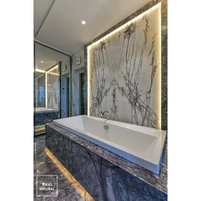 This bathroom is a masterpiece of marble. We used a dramatic, book-matched slab as an accent wall behind the bathtub, with backlighting to highlight its natural veining and create a stunning focal point.