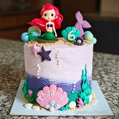 A mer-mazing cake for a mermaid lover. This 10-inch tall, double-barrel chocolate buttercream cake is decorated with waves, edible sand, and plenty of under-the-sea fondant details.