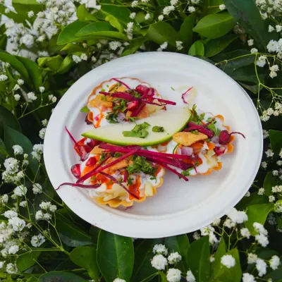 A modern take on chaat, served in bite-sized tart shells and garnished with pomegranate, beetroot, and a slice of raw mango. It's a burst of flavor in every bite.