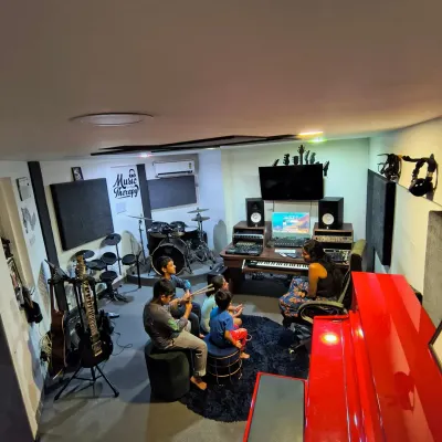 A high-angle view of our acoustically treated studio and rehearsal space. It's equipped with everything you need to write, record, or practice, including our standout red Pearl River piano.