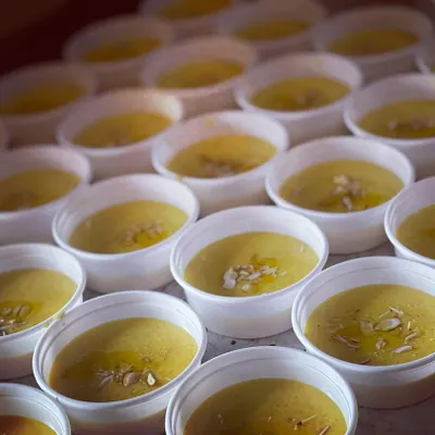 Individual portions of Muzzafar, a rich vermicelli-based sweet, prepared for a wedding event. Each bowl is garnished with nuts.