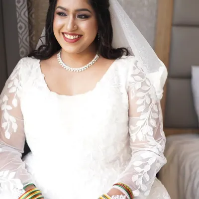 This bride's smile radiates pure joy during her church wedding celebration. I created a soft, timeless look to complement her beautiful white lace gown, focusing on radiant skin and defined eyes that sparkle with happiness.