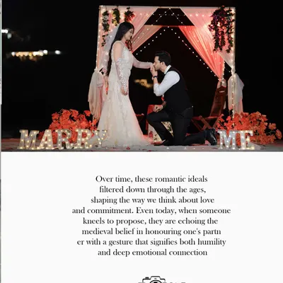 A classic proposal scene at night, with the groom-to-be on one knee and illuminated "MARRY ME" letters creating a magical ambiance.