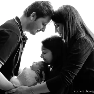 A beautiful black and white portrait of a family of four adoring their newest member. These newborn family sessions are perfect for capturing the love that fills the room.