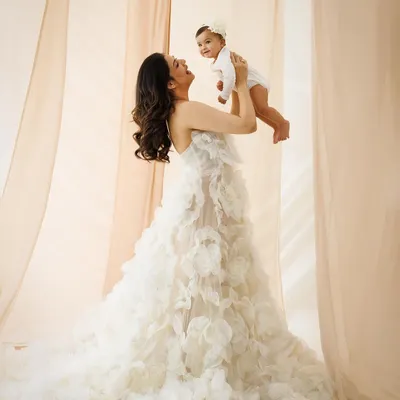 This portrait embodies the elegance and grace of motherhood. The flowing gown and soft lighting create a truly radiant and aspirational image, celebrating the powerful connection between a mother and her child.