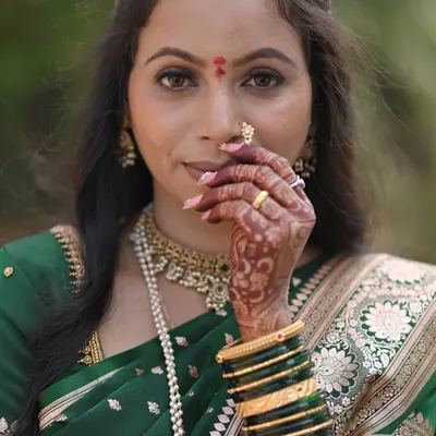 A beautiful bride wearing her custom press-on nails. I designed this set with a soft pink base and delicate details to match her traditional green wedding attire.