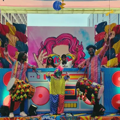 On stage at a massive Holi event, surrounded by dhol players and vibrant decor. There's nothing like the energy of a festival party, and I love being at the heart of the celebration.