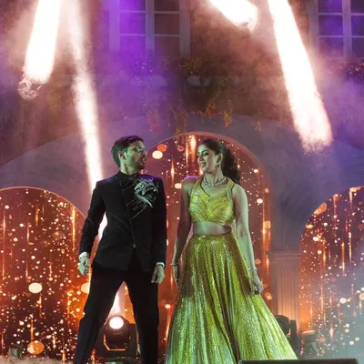 The couple's entry sets the tone for the night. For this Sangeet, we used dramatic stage lighting and a cloud of smoke to create a magical reveal for the shining stars of the evening.