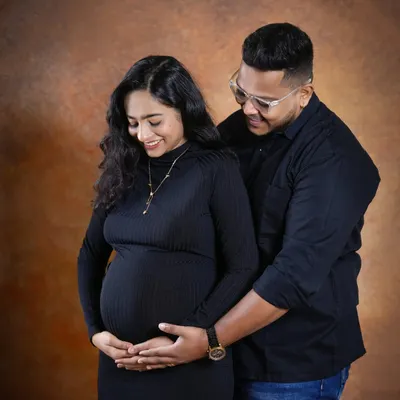 A tender moment between partners, both gently holding the baby bump. This pose emphasizes their shared journey and the love that surrounds their growing family.