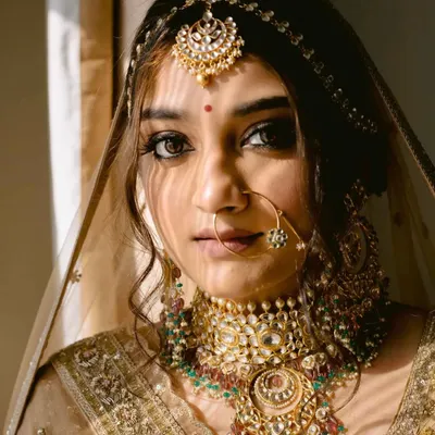 A bride bathed in a sliver of sunlight, the shadows creating a dramatic and captivating portrait. Her gaze is direct, her presence powerful.