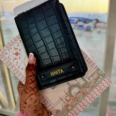 Your passport, your adventure. This stylish black passport cover is personalized with a name, making it the perfect accessory for your next journey.