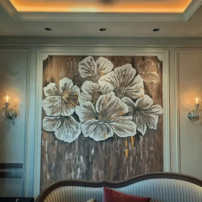 The final view of the textured floral mural, perfectly centered in an elegant bedroom. The warm lighting highlights the raised texture of the petals, creating a stunning focal point.