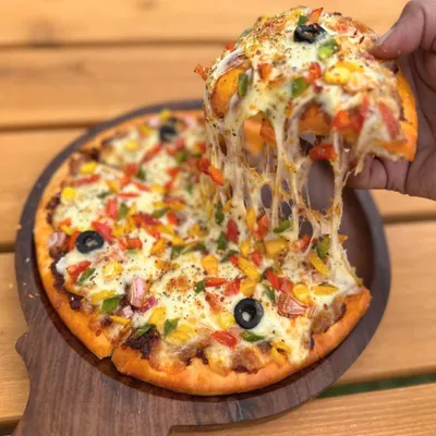 Nothing beats a cheesy pizza pull! Our Veggie Delight Pizza is a favorite among human guests at the "Think Pawsitive" Cafe.