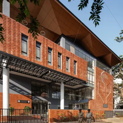 The exterior of the Nirbhaya Centre in Bangalore, featuring a distinctive brick mural and a welcoming entrance shaded by a 100-year-old raintree.