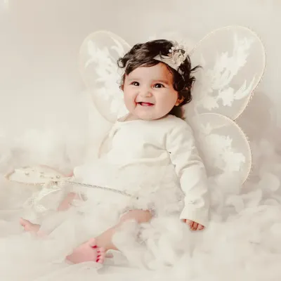 A little angel with delicate fairy wings, sitting on a bed of soft clouds. My themed sessions are designed to create magical, dream-like portraits.