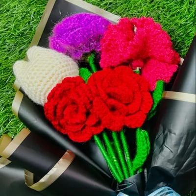 This custom bouquet features bright red roses, a white tulip, and other colorful flowers, all handmade and wrapped in elegant black paper for a striking contrast.