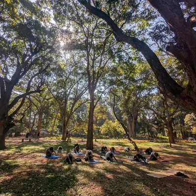 The sun filtering through the trees is our studio ceiling. Here, we find our space on the grass, ready to begin our weekly ritual of outdoor yoga in the heart of Bangalore.
