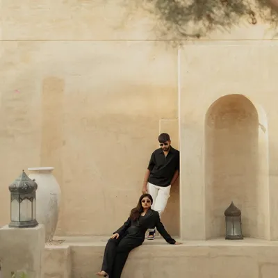 A high-fashion, editorial-style shot of Kinjal and Yash in Dubai, using the clean, sand-colored architecture to create a modern and chic portrait.