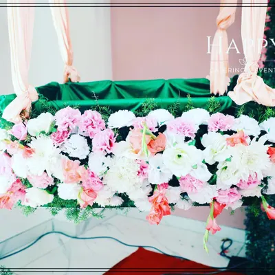 A close-up of the floral decoration on a naming ceremony cradle. We use a fresh mix of pink, white, and peach flowers to create a soft and beautiful look.