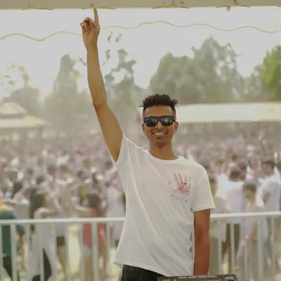 Do me a favor, let's play Holi! A shot of me before the colors hit, with a massive crowd ready for the Desi Holi festival.