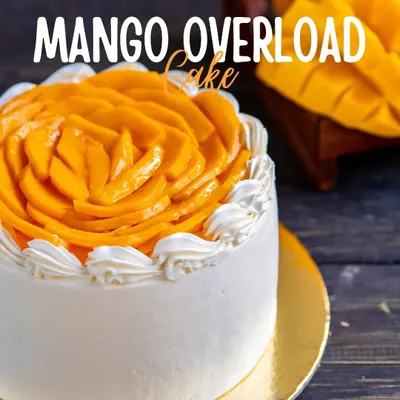 This is our Mango Overload cake, and we mean it! It's topped with a beautiful rose made of fresh mango slices, offering a true mango extravaganza.