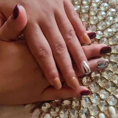 A sophisticated set combining solid maroon, nude, and striking silver chrome accent nails on short, square extensions.
