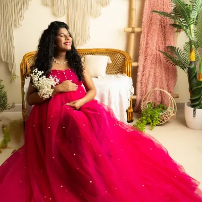 A joyful, candid moment in a vibrant pink tulle gown. The boho-chic studio setup with natural light creates a relaxed and happy atmosphere.