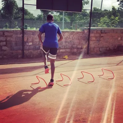 An advanced player works on his agility and speed with hurdle drills. This type of plyometric training is essential for explosive movements on the court.