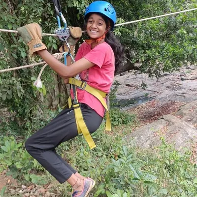 A young participant smiles as she glides across on a zipline. Our youth camps are filled with thrilling activities that are both safe and incredibly fun.