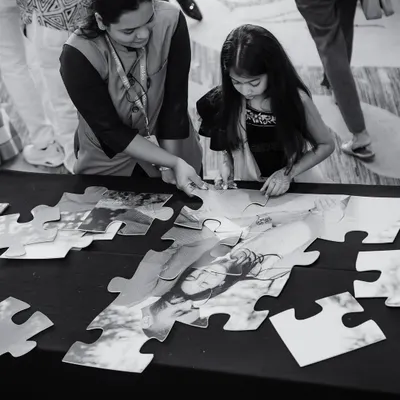 It's the little things that matter most. Here, a young guest is engaged with a custom jigsaw puzzle featuring a photo of the couple.
