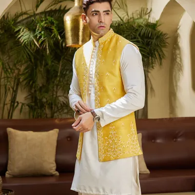 Embrace the spirit of the Haldi ceremony with this vibrant yellow embroidered jacket. Paired with a simple white kurta, it's a look that is both festive and sophisticated.