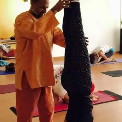 Guiding a student into a stable Sirsasana (Headstand). Proper alignment is key to receiving the full benefits of this master asana.