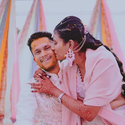 A sweet, candid moment from a Haldi ceremony, with the bride giving the groom a playful kiss on the cheek. These are the real, unposed memories I love to capture.