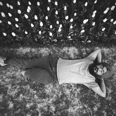 A self-portrait taken in a field of tulips, a moment of quiet contemplation. For me, connecting with nature and finding time for stillness is just as important as the time I spend drawing; it is where many of my ideas begin.