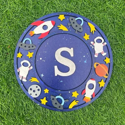 Create a stellar piece of decor with my space-themed monogram kit. This "S" plaque is surrounded by hand-painted astronauts, rockets, and planets. It's the perfect personalized project for any aspiring space explorer.
