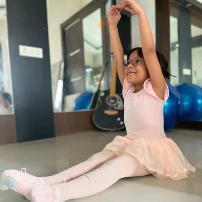A young ballerina practices her arm positions with a smile. My classes are designed to be enjoyable while teaching the core principles of ballet.