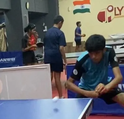 A young player executing a low shot during a match. This image represents the focus and determination of our athletes, like Vivyan Gada and Trissha Ludbe, who secured medals in the TSTTA District Ranking Tournament.