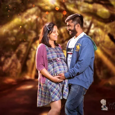 I love using natural landscapes to create a magical feel. Here, a couple shares a quiet moment on a tree-lined path, with soft lighting adding a touch of enchantment to their pregnancy portrait.