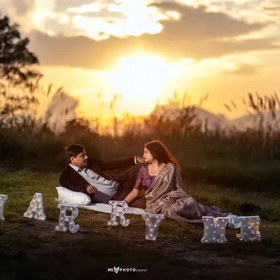 A perfect sunset proposal scene. I set up "Marry Me" light-up letters and a picnic blanket for this couple's special moment in a grassy field overlooking the mountains.