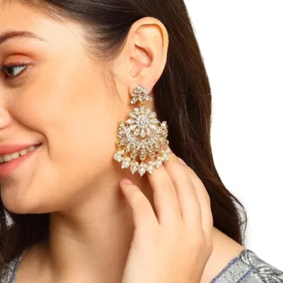 A model showcasing our stunning kundan and pearl earrings. These are designed to be large and impactful, perfect for a wedding or festive event, yet feel comfortable to wear.