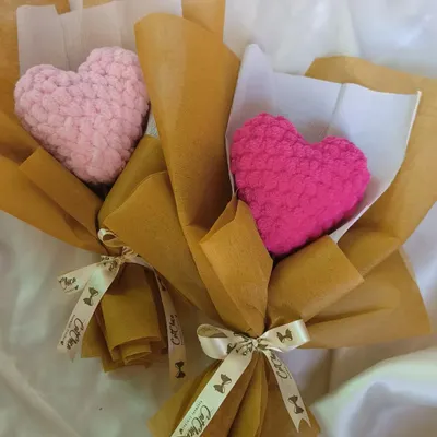 Two of our plushie heart bouquets side by side, one in a soft baby pink and the other in a vibrant magenta. They show the different color options available for this unique gift.