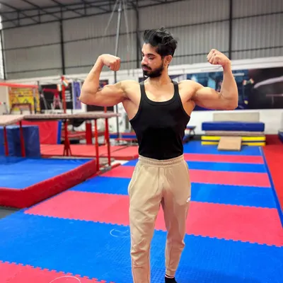 A shot of me, Coach Afjal, at the academy. My goal is to transfer my years of experience as a competitive gymnast to every student who walks through our doors.