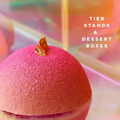 A close-up of a vibrant pink, textured dessert sphere, part of our offering for festive gifting. Our tier stands and dessert boxes are a lovely way to share a taste of our studio.