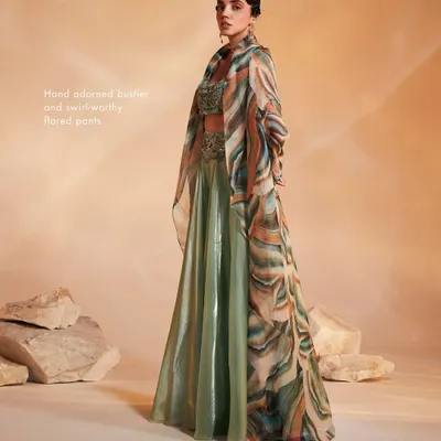 The Adoree Cape Set in a striking sage green with a multi-color printed oversized cape. The hand-adorned bustier and flared pants create a perfect balance of modern and traditional.