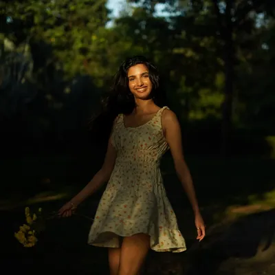 A beautiful, candid-style portrait in a sun-dappled park. The play of light and shadow creates a dreamy, natural mood for this simple summer dress.