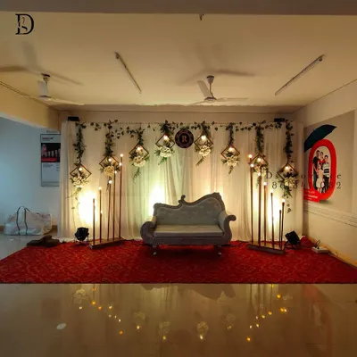 A full view of an elegant stage setup for a wedding or reception. I capture the entire scene, including the floral arrangements, lighting, and central seating, to preserve the memory of your event's look.