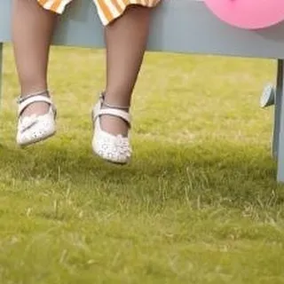 A close-up detail shot of a baby's sweet little shoes, taken during an outdoor birthday session. These are the details you'll want to remember forever.